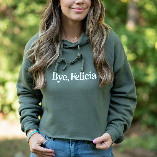 Person wearing a green hoodie with 'Bye, Felicia' text outdoors