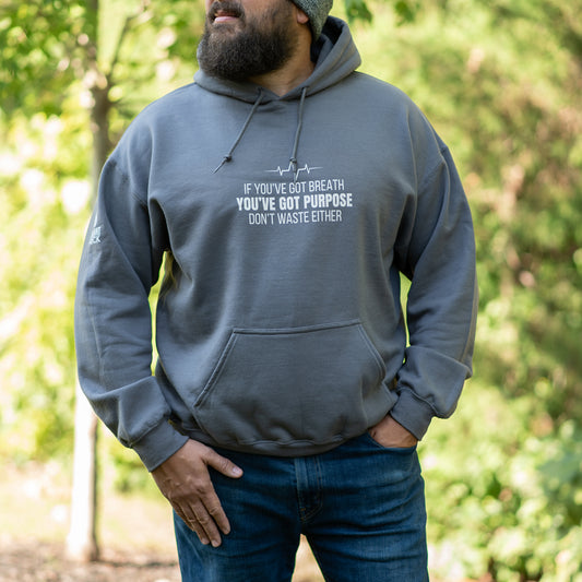Person wearing a gray hoodie with a motivational quote outdoors