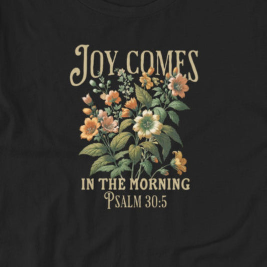 Black t-shirt with floral design and text 'Joy Comes in the Morning Psalm 30:5' on a plain background