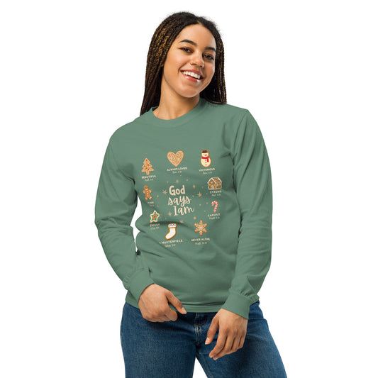 Model wearing a green long sleeve tee that has decorated Christmas cookie images listed next to a quality that God says I am. Christian apparel.