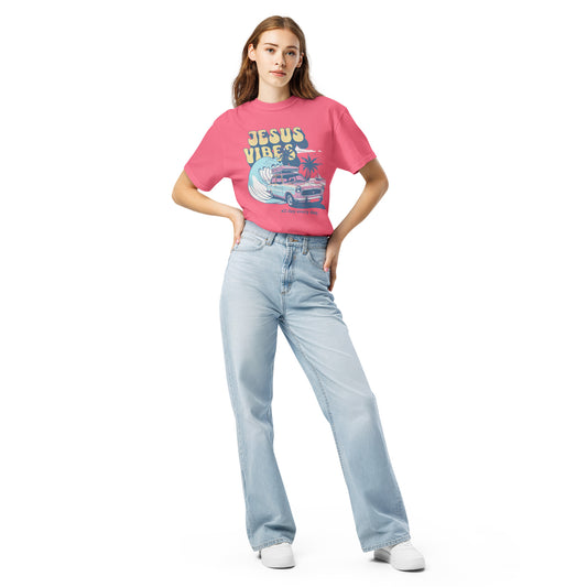 Female model wearing ‘Jesus Vibes’ crunchberry pink t-shirt featuring pastel vintage car, wave, palm trees, and the phrase ‘all day every day.