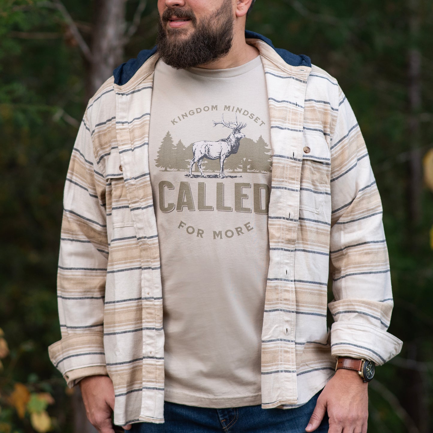 Man wearing Called for more kingdom mindset t-shirt with a stag and tree line. Minimalist. Christian shirt.