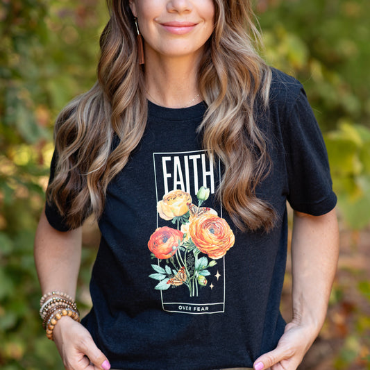 Faith over Fear floral tee on woman. Bold 'Faith' above flowers, small 'Fear' below on black shirt.