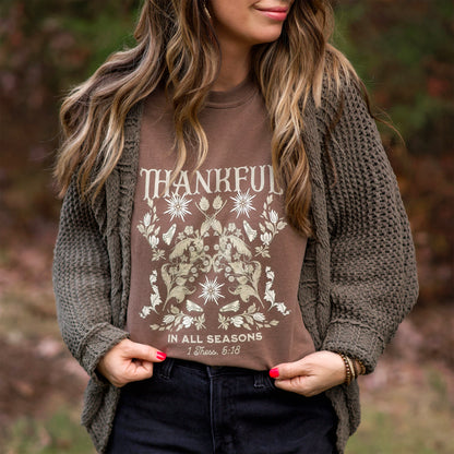 Woman wearing a brown 'Thankful in All Seasons' shirt outdoors