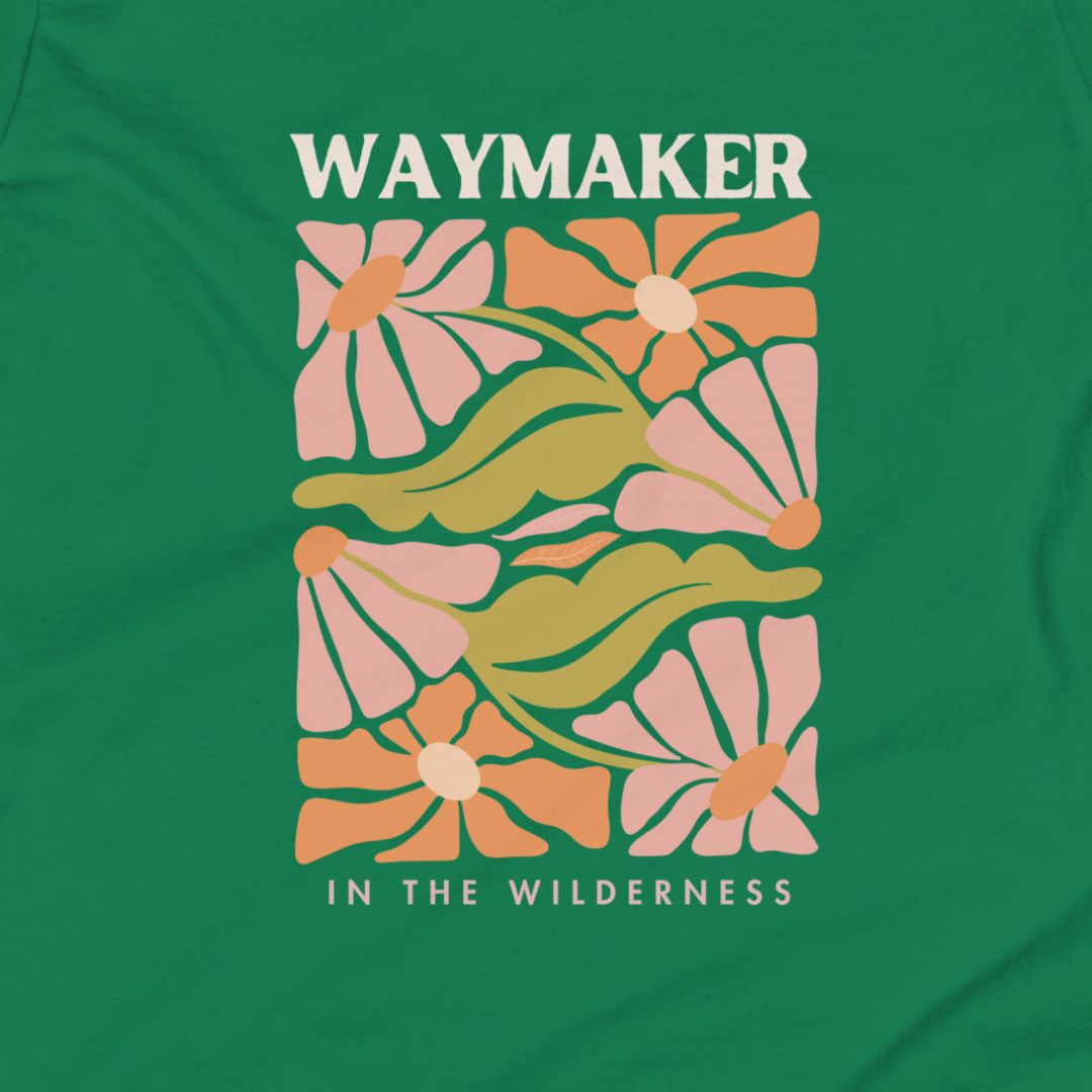 Green t-shirt with floral design and 'Waymaker in the Wilderness' text on a green background