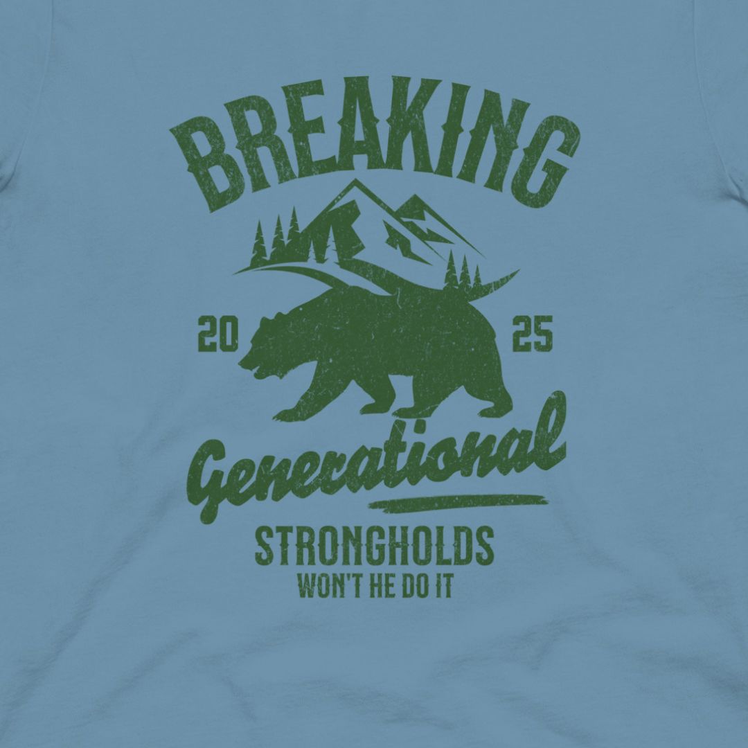 Light blue t-shirt with green graphic design featuring a bear, mountains, and text on a light blue background.