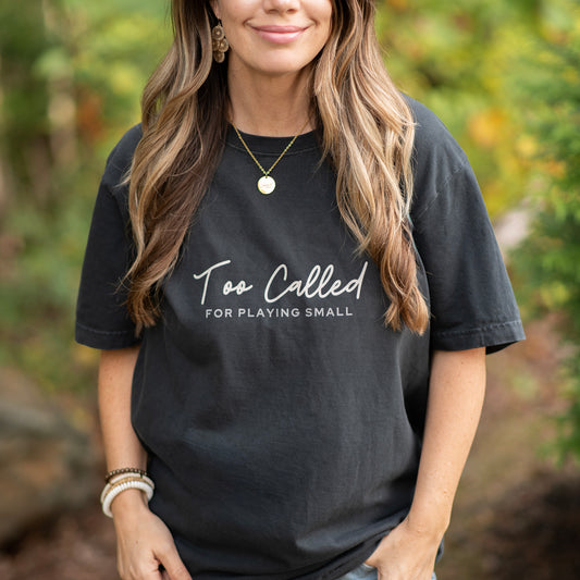 Model wearing Too Called For Playing Small oversized t-shirt while outside. Faith based shirt, modern style.