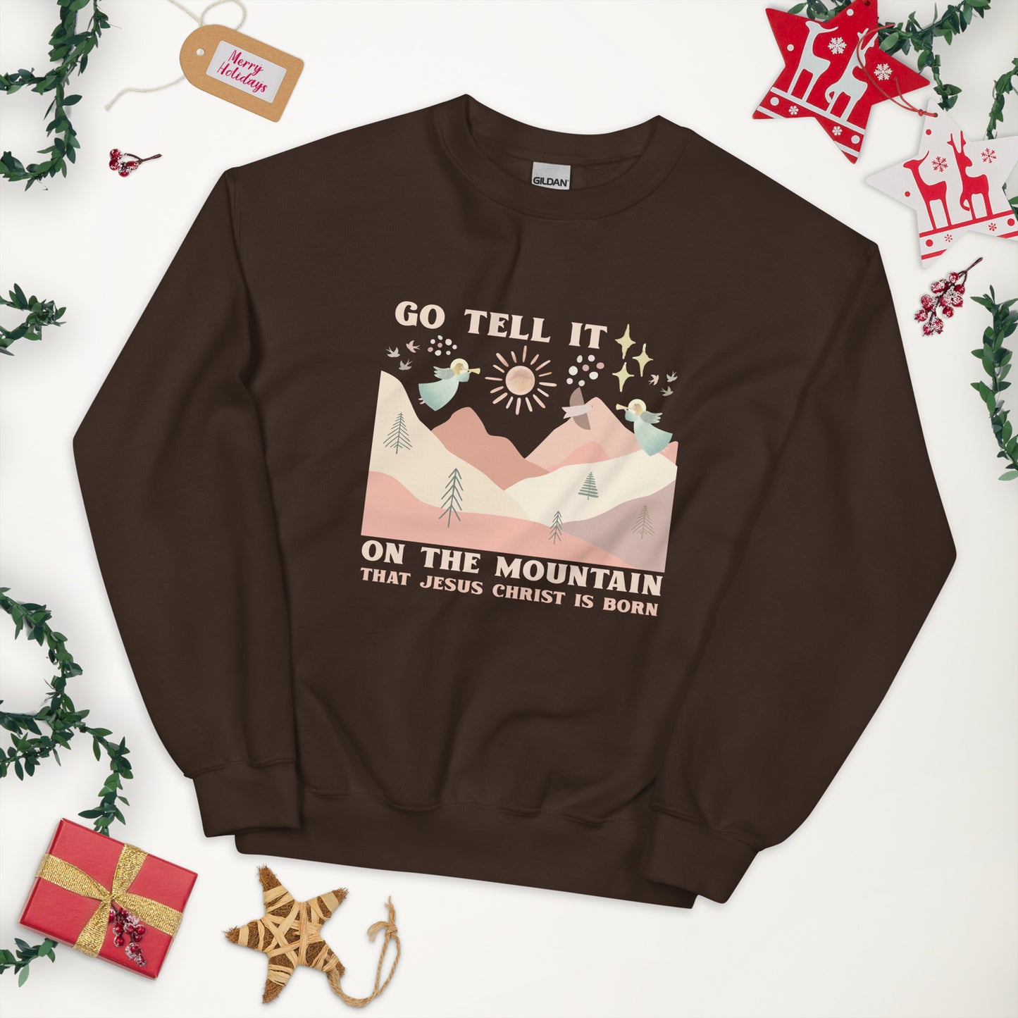 Dark chocolate colored sweatshirt with image of angels playing trumpets over the hills and mountains, with star of Bethlehem and doves in the background. Go tell it on the mountain that Jesus is born.