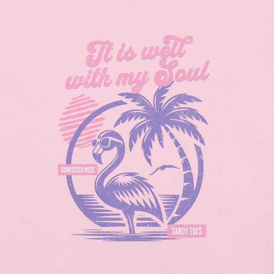 Blossom pink “It Is Well” Christian t-shirt featuring retro flamingo, palm trees, and beach sunset design in pink and purple tones.