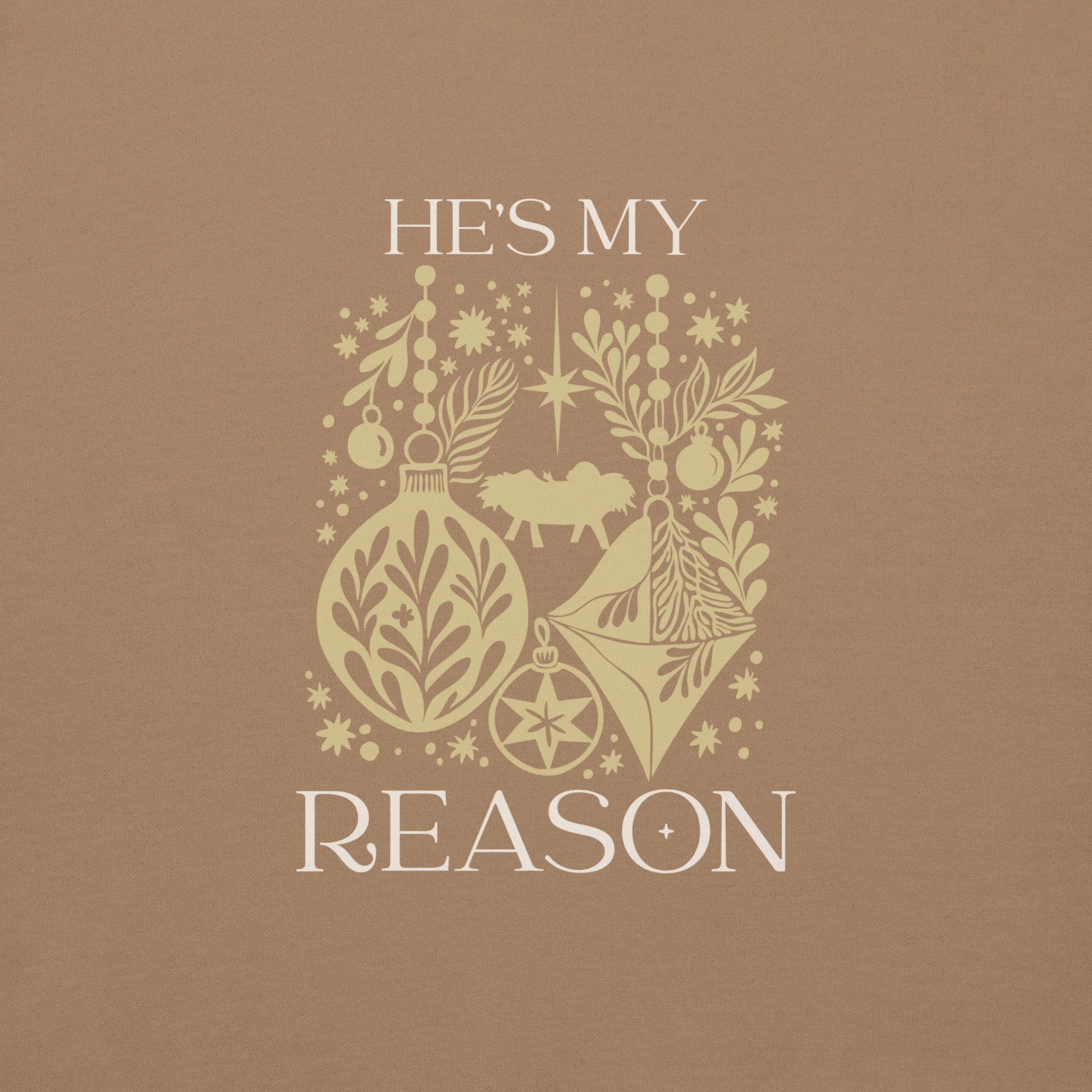 Gold "He is my reason" text with silhouette collage of ornaments, baby Jesus, stars, snowflakes on a latte colored sweatshirt